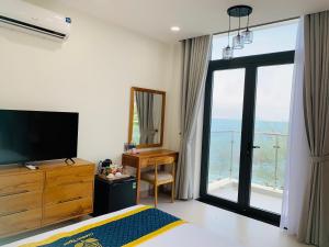 a bedroom with a bed and a desk and a television at Golden Rose Hotel in Con Dao