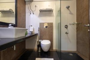 a bathroom with a toilet and a sink and a shower at Hotel 91 Golf Course Road in Gurgaon