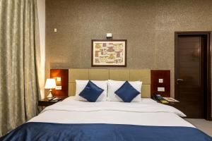 a bedroom with a bed with blue and white pillows at Hotel 91 Golf Course Road in Gurgaon