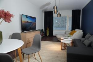 a living room with a couch and a tv at Easypass Apartmenthotel in Helsinki