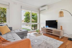 a living room with a couch and a flat screen tv at NEW! Modern, Relaxing 2BR Retreat in Mentone, Victoria in Mentone
