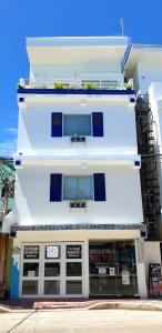 biały budynek z oknami wychodzącymi na ulicę w obiekcie Lugar Bonito Hotel w mieście Boracay
