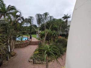 Une planche de surf est installée à côté d'une piscine bordée de palmiers. dans l'établissement Breakers Resort, Umhlanga, à Durban