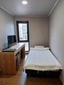 um quarto com uma cama e uma secretária com um computador em J.Hill House em Seul