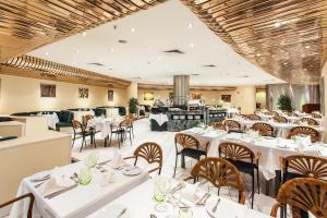 a dining room with white tables and chairs at Holiday Inn Lisbon-Continental by IHG in Lisbon