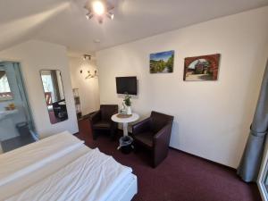 ein Hotelzimmer mit einem Bett, einem Tisch und Stühlen in der Unterkunft Pension Haus Diefenbach in Heimbach
