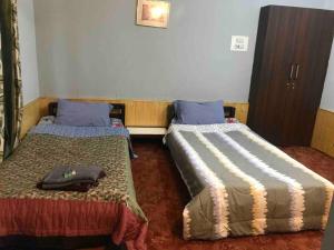 a room with two beds in a room at Well-equipped modern flat with 24/7 security in Srinagar
