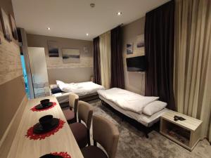 a hotel room with two beds and a table and chairs at Gondola Studio Brzeće Kopaonik in Brzeće