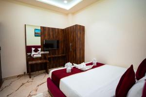 a hotel room with a bed and a television at HOTEL JSR KEDAR in Varanasi
