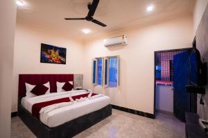 a bedroom with a large bed with a red headboard at HOTEL JSR KEDAR in Varanasi