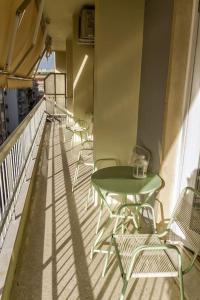 - Balcón con mesa verde y sillas en Apartment in the heart of the city en Atenas