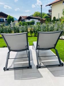 duas cadeiras sentadas uma ao lado da outra num pátio em Das Bad Wiessee 22 em Bad Wiessee