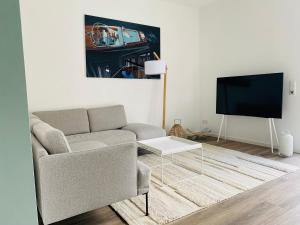 a living room with a couch and a tv at Das Bad Wiessee 22 in Bad Wiessee
