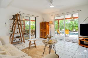 uma sala de estar com um sofá e uma mesa em Villa Célestine, à 2 pas du lagon de la Saline em La Saline-Les-Bains