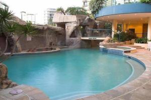 a large swimming pool with a waterfall in a building at Landmark Resort Mooloolaba 4th Floor Apartment with a View in Mooloolaba