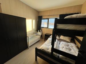 a bedroom with two bunk beds and a crib at Lyngvær Luggombu in Kleppstad