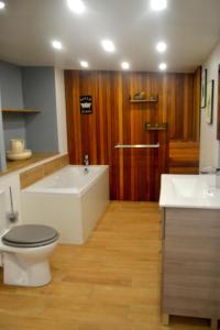 a bathroom with a tub and a toilet and a sink at Les Gîtes de Monthermé L'Appartement belvédère sur Monthermé in Monthermé
