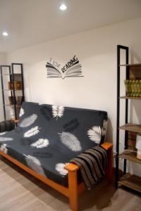 1 dormitorio con 1 cama con un libro en la pared en Appartement du Pont Monthermé en Monthermé