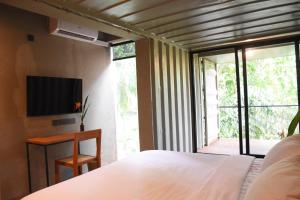 YatiyantotaにあるRiver Pavilion, Kitulgalaのベッドルーム(ベッド1台、テレビ、窓付)