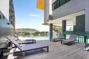 balcón con tumbonas y piscina en Central Hill View Condo A716D*2BR Apartment*Ideal Location: Shopping, Relax, Adventure, en Ban Ket Ho