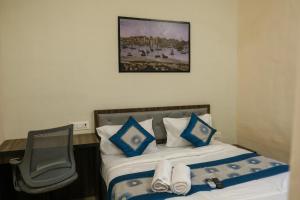 a bedroom with a bed with blue and white pillows at VR Comforts in Mumbai