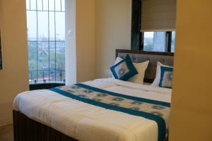 a bedroom with a large bed with a window at VR Comforts in Mumbai