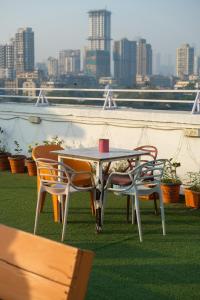 a table and chairs on a balcony with a view of a city at VR Comforts in Mumbai
