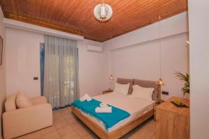 um quarto com uma cama e uma cadeira em AκrotiriResort em Vasiliki