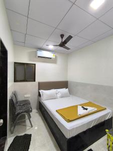 een slaapkamer met een groot bed en een plafond bij Sapna Lodging & Boarding in Mumbai