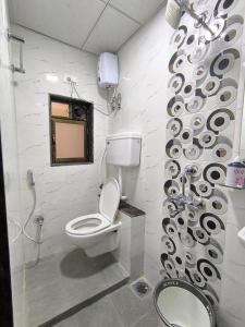 een badkamer met een toilet en een douche bij Sapna Lodging & Boarding in Mumbai