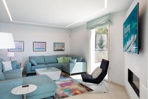 a living room with a blue couch and chairs at VILLA ILLA BLANCA in Tamariu