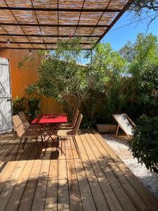 a patio with a table and chairs on a deck at Petite maison cocooning classée 3 étoiles à Bormes les mimosas in Bormes-les-Mimosas