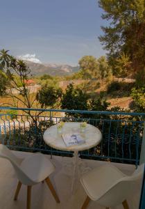 un tavolo e sedie su un balcone con vista di AκrotiriResort a Vassiliki