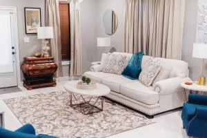 a living room with a white couch and a table at Country Cottage - Broussard in Broussard