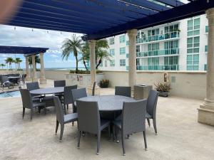 a patio with tables and chairs and a building at Bay Front Highrise Oasis in Brickell in Miami