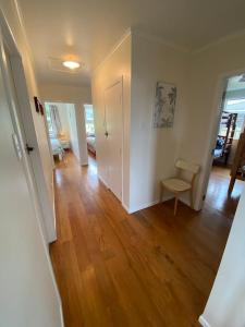 an empty living room with wooden floors and a hallway at Rotorua Forest Getaway in Rotorua