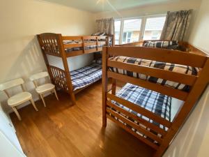 two bunk beds in a room with a table and chairs at Rotorua Forest Getaway in Rotorua