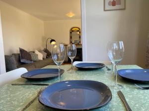 a table with blue plates and wine glasses on it at Rotorua Forest Getaway in Rotorua