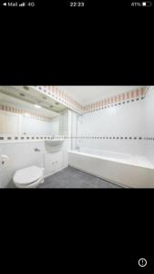 a bathroom with a toilet and a bath tub at Oxford Street Two Bed Apartment in London