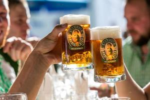 a person holding up two glasses of beer at Kempten - Lebendig und voller Geschichte in Kempten