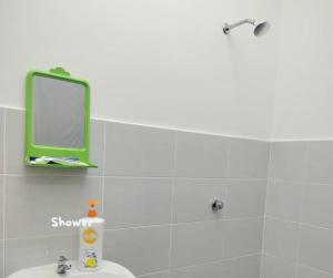 a bathroom with a green mirror and a sink at Umar's Lodge in Bemban