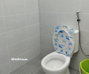 a bathroom with a toilet with a seat with blue birds on it at Umar's Lodge in Bemban