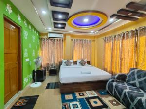 a bedroom with a bed in a room with yellow walls at Hotel Green Wood in Siliguri