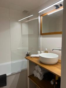 La salle de bains est pourvue d'un lavabo blanc et d'une douche. dans l'établissement Petite maison cocooning à Bormes les mimosas, à Bormes-les-Mimosas