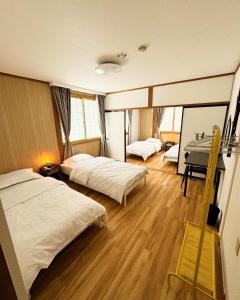 a hotel room with two beds and a desk at HAKUBA76 in Hakuba