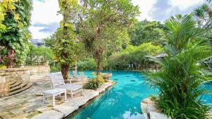 梭羅的住宿－洛林索羅酒店，庭院里一个带两把椅子和树木的游泳池