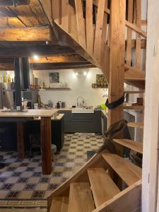 a large kitchen with wooden stairs in a kitchen at Maison de village de 1802, fraîchement rénovée à Beauvezer 04370 in Beauvezer