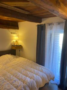 BeauvezerにあるMaison de village de 1802, fraîchement rénovée à Beauvezer 04370のベッドルーム1室(ベッド1台、青いカーテン付きの窓付)