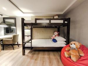 Citrus Suites Sukhumvit 6 by Compass Hospitality في بانكوك: وحشرتان جالستان على سرير بطابقين