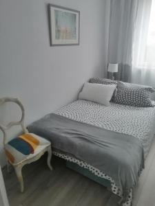 1 dormitorio pequeño con 1 cama y 1 silla en Apartament szafirowa25 pietro1, en Kołobrzeg